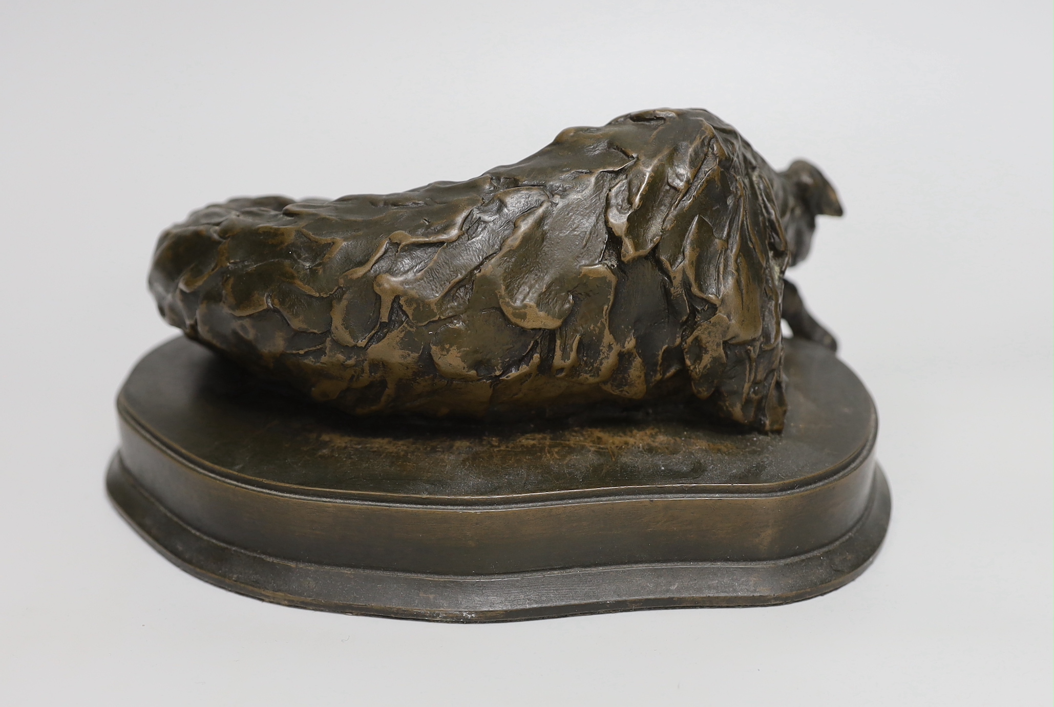 A bronzed resin model of a recumbent dog, 25cm long
